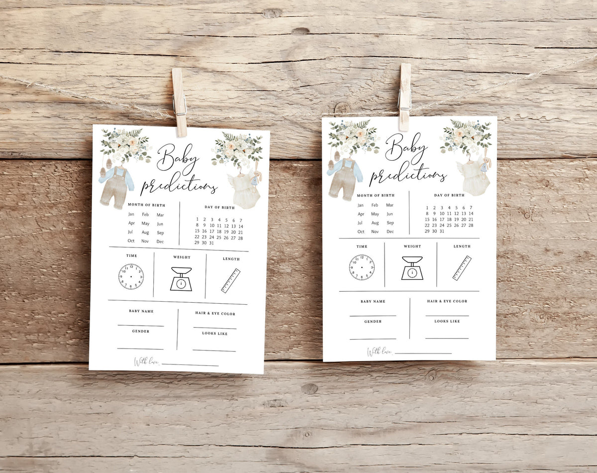 Two boho baby prediction cards with blue and cream outfits hanging against a wooden backdrop