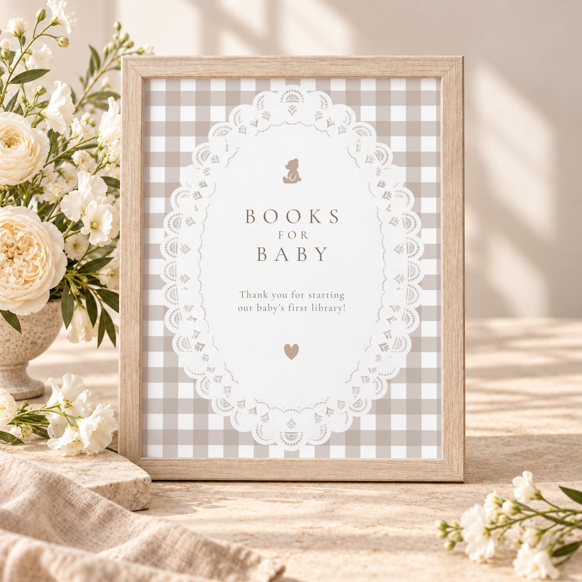 Books for Baby sign with teddy bear, white lace and beige gingham in a wooden frame with white flowers