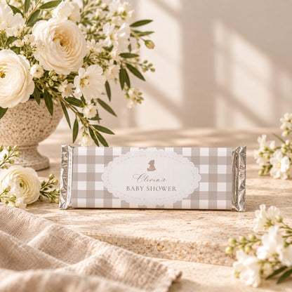 Chocolate bar with a personalized teddy bear gingham baby shower wrapper next to white flowers